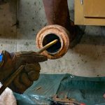 Plumber repairing leak in sink of a house in kitchen