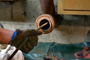 Plumber repairing leak in sink of a house in kitchen