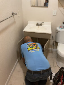 Plumber performing drain replacement under bathroom sink in Dunedin, FL