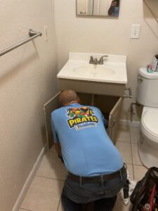 Plumber repairing bathroom sink plumbing in Oldsmar FL