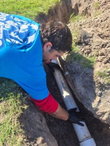 Plumber installing underground PVC sewer pipe in New Port Richey FL