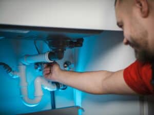 Licensed plumber repairing under-sink drain and P-trap in a Palm Harbor, FL home