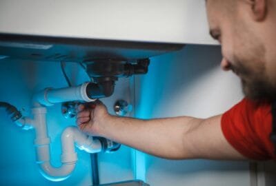 Licensed plumber repairing under-sink drain and P-trap in a Palm Harbor, FL home
